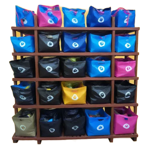 A row of blue, black and pink bags sitting on a shelf.