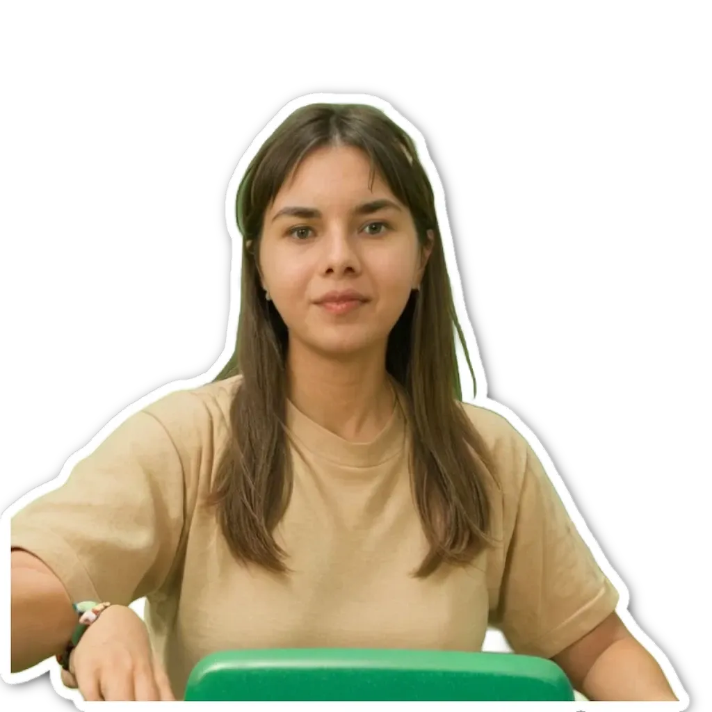 A girl wearing a brown shirt is sitting at a green box.